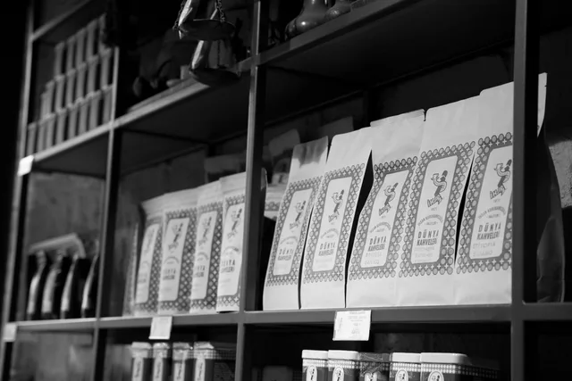 A monochrome image of coffee bags neatly arranged on a store shelf, creating an organized display. Filialabdeckung mit Produktdistribution abgleichen